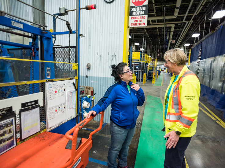 Two women speaking on the manufacturing floor