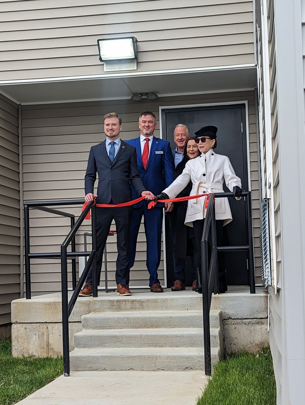 /group%20of%20people%20cutting%20ribbon%20on%20stairs.