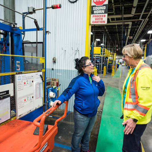 Two women speaking on the manufacturing floor