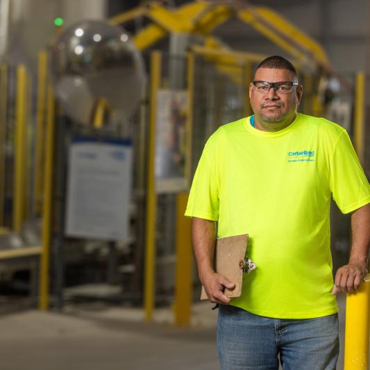 An engineer wearing bright safety gear, representing growth and opportunity for anyone pursuing a manufacturing engineer career path.
