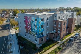 A large apartment complex with a Patriotic mural on the side 