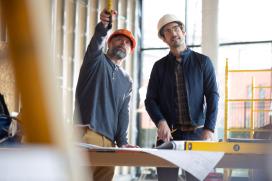 2 workers in safety gear on a job site
