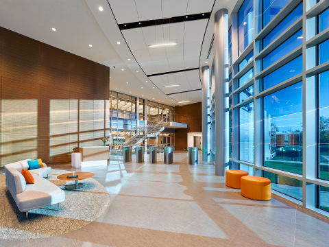 Lobby entrance with floor-to-ceiling glass on the right and a wooden wall on the left.